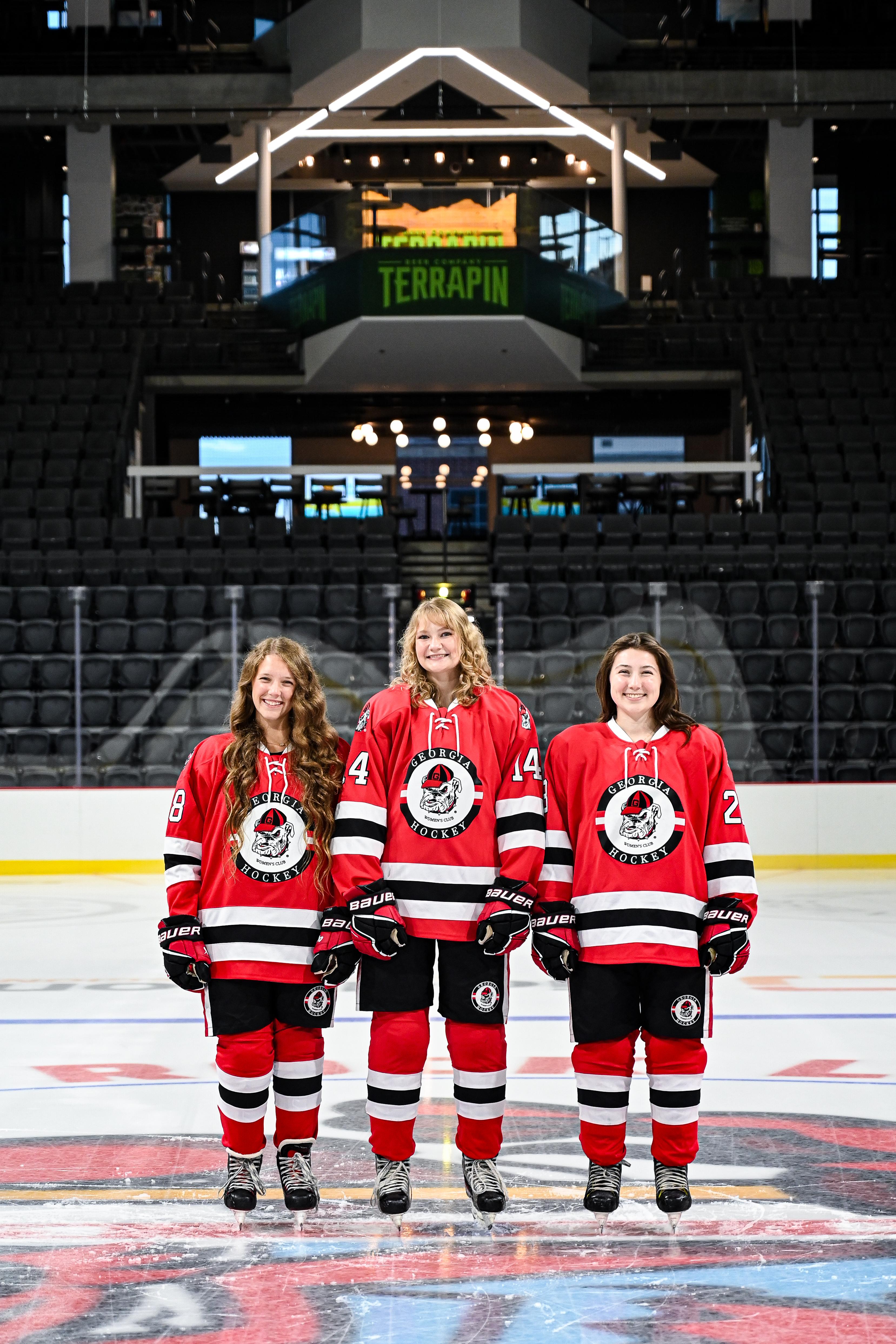 Three female hockey players, from left Rachael, Eva, Georgia, smiling for the camera in a team photoshoot.
